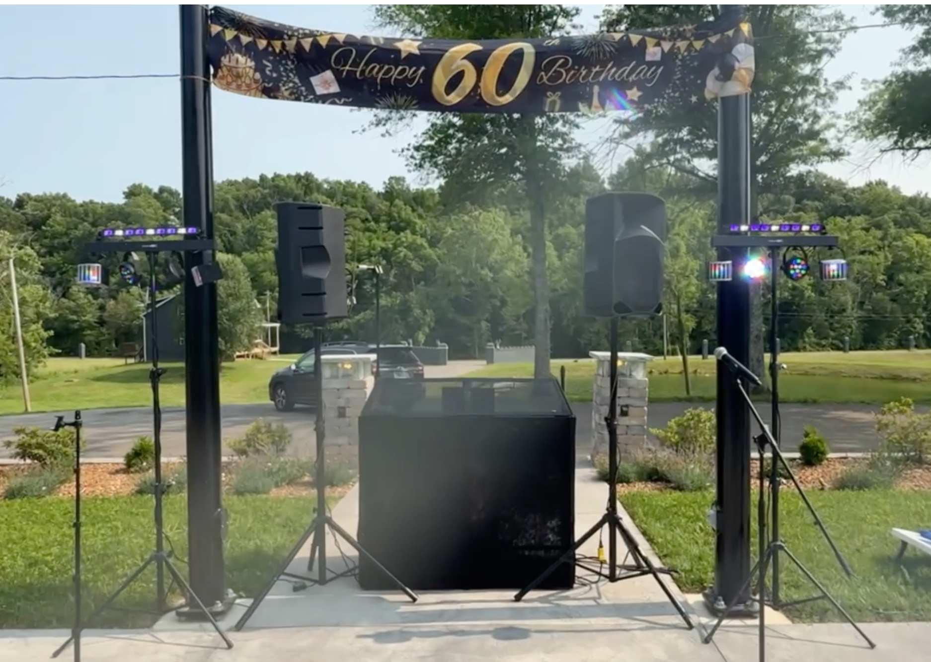 Outdoor birthday party DJ and speaker setup under a covered patio