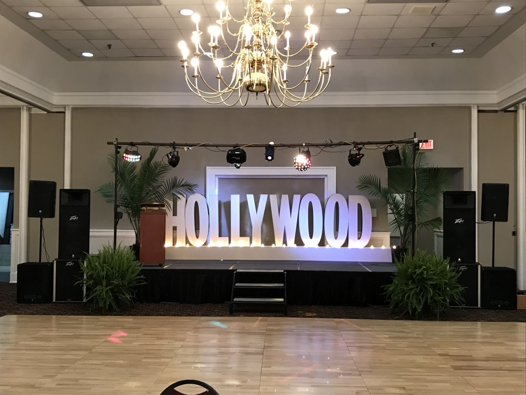Ballroom stage setup with speakers, lighting, and Hollywood letters